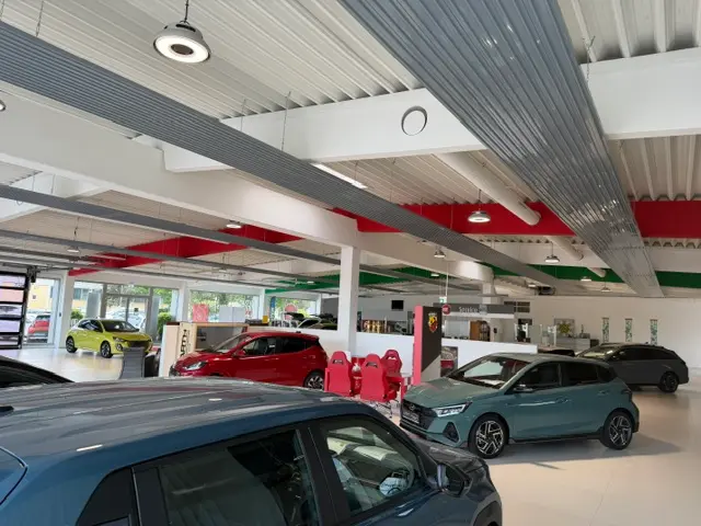 Das innere des Autohauses mit Autos und Stühlen