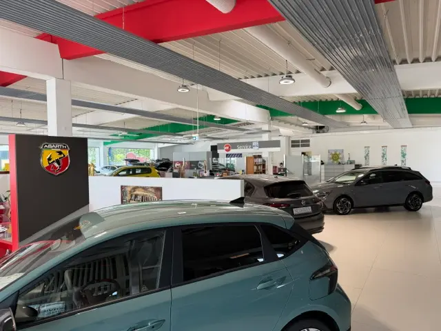 zu sehen: Verkaufshalle mit mehreren Autos und Abarth Logo