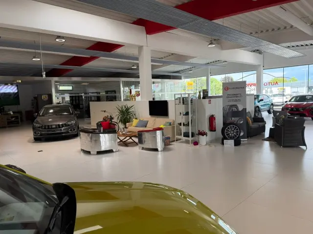 zu sehen: Verkaufshalle mit Autos und einer sitzecke
